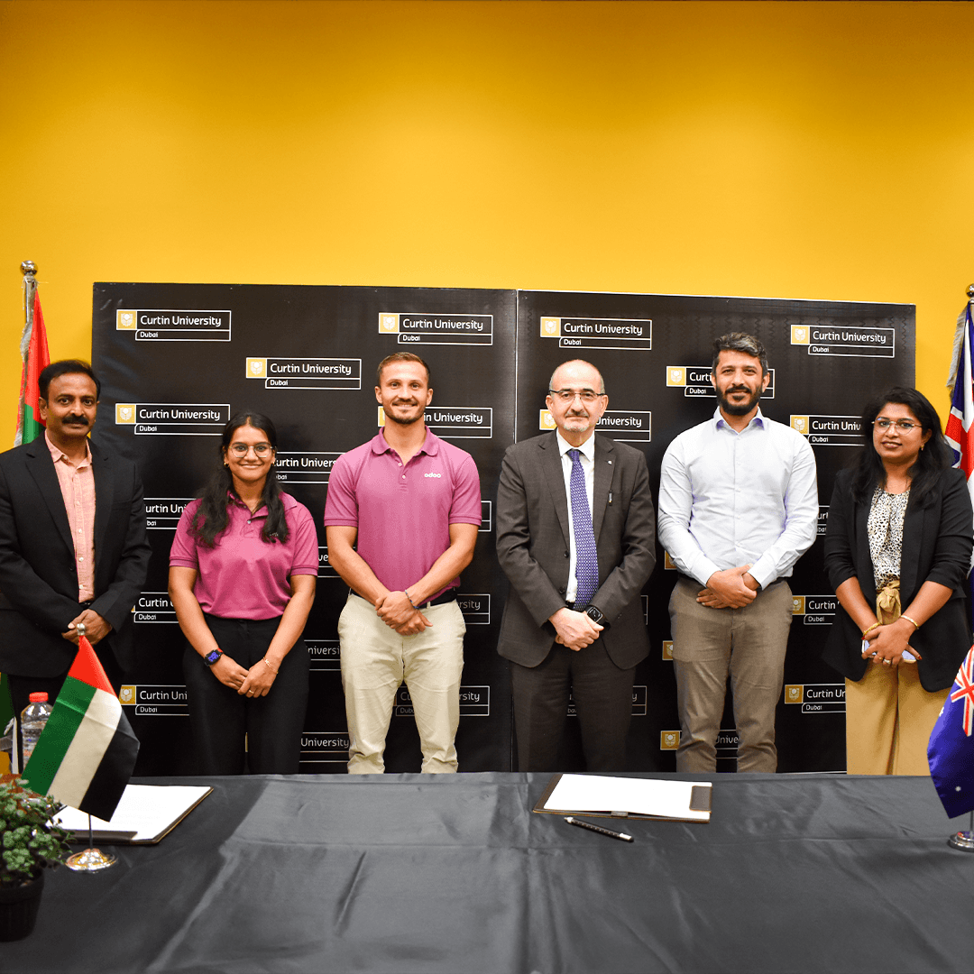 A group photo of representatives from the university and industry partner standing together during the official Curtin University Dubai and Odoo MoU signing event.