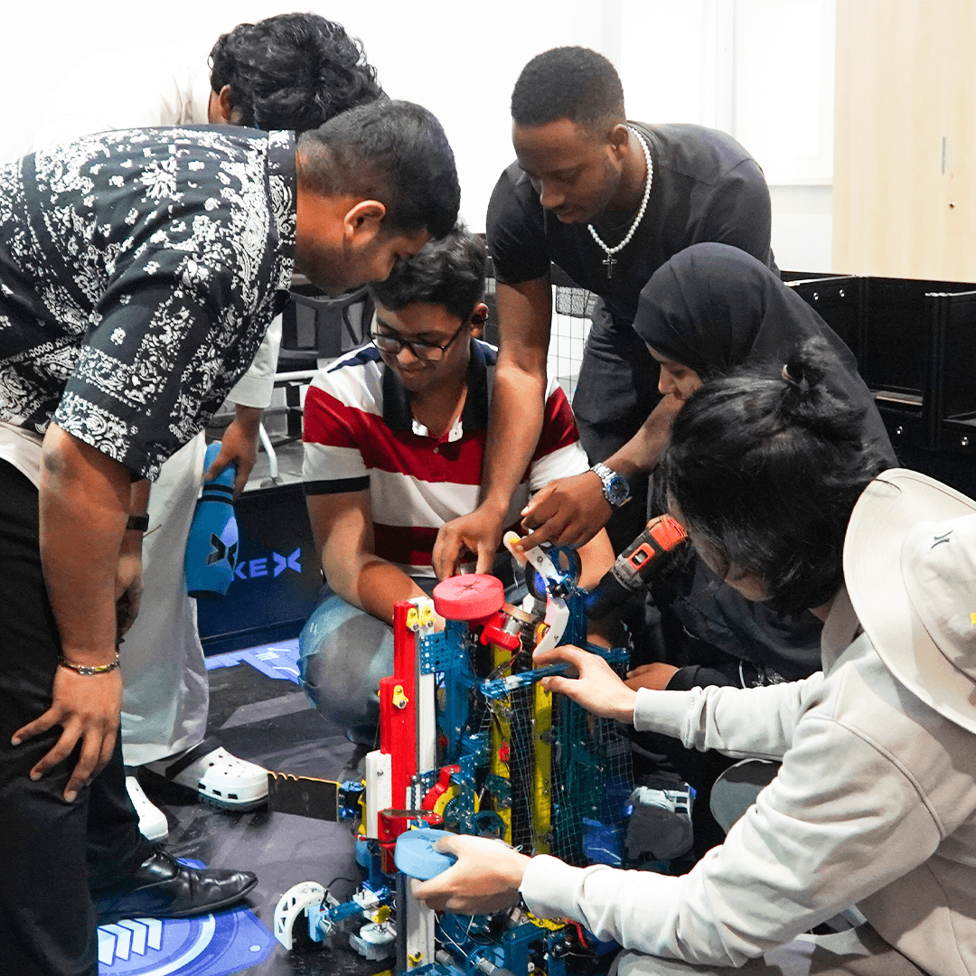 Engineering students collaborating on a robotics project using mechanical design and technology